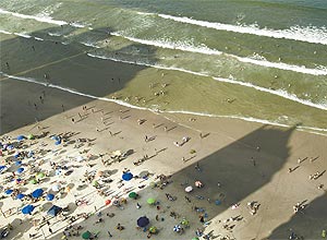 Sombras de prédios altos "rouba" o sol dos turistas na orla de Balneário Camboriú