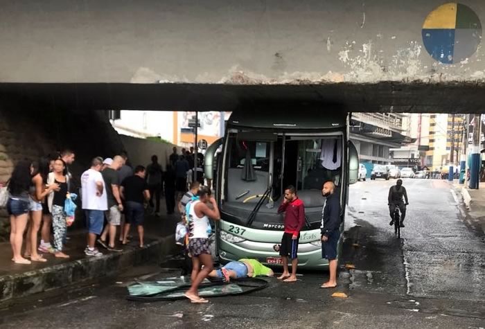 Ônibus entala em viaduto e guia é arremessado pelo para-brisa
