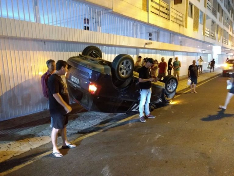 Caminhonete colide em carro estacionado e capota na Rua 1400