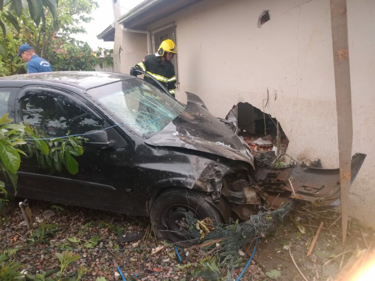 Carro colide em casa após saída de pista na Rod. Antônio Heil